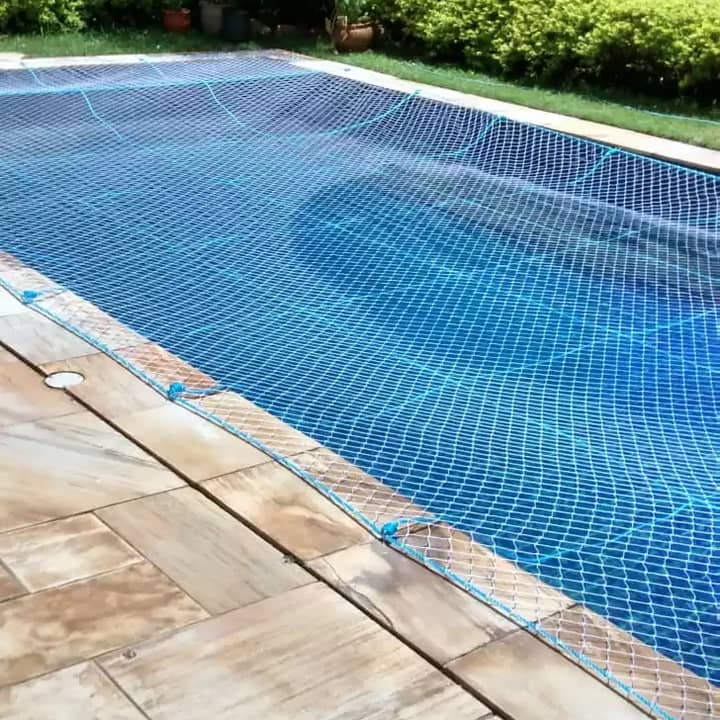 Piscina coberta por rede de proteção azul e branca